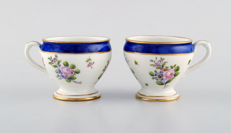 Sevres, Frankrig. To antikke cremekopper i håndmalet porcelæn med blomster og 
gulddekoration. 1800-tallet. 
