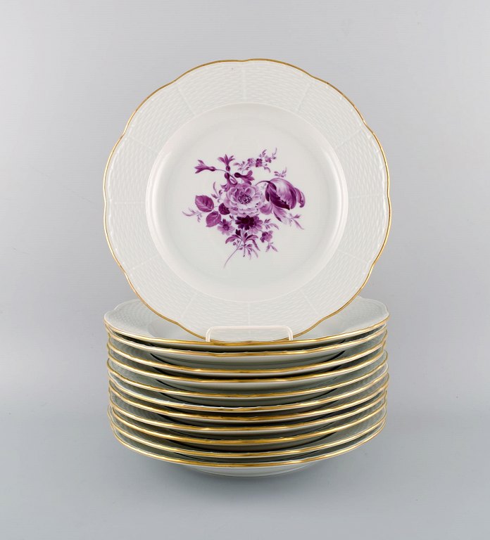 Tolv antikke Meissen middagstallerkener i håndmalet porcelæn med lilla blomster 
og guldkant. Ca. 1900.
