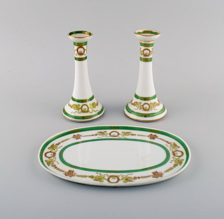 Limoges, Frankrig. To lysestager og et fad i håndmalet porcelæn med grøn kant og gulddekoration. 1930/40