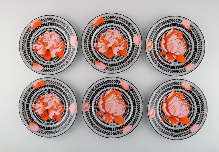 Six Hermès porcelain lunch plates decorated with red flowers on a black and 
white patterned background. 1980s.
