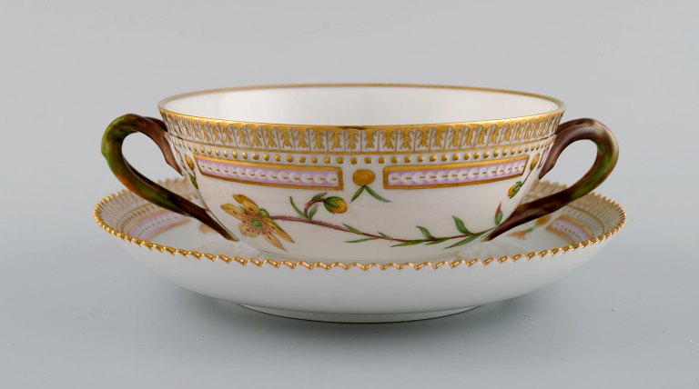 Royal Copenhagen Flora Danica boullionkop med underkop i håndmalet porcelæn med 
grenformede hanke, blomster og gulddekoration. Modelnummer 20/3612.  
