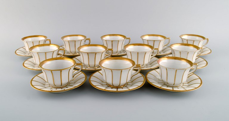 Tolv antikke Royal Copenhagen Kantet 447 kaffekopper med underkopper i håndmalet 
porcelæn med gulddekoration. Sent 1800-tallet.
