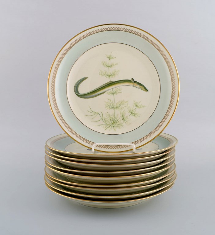 10 Royal Copenhagen fisketallerkener i porcelæn med håndmalede fiskemotiver og 
gulddekoration. Dateret 1960.
