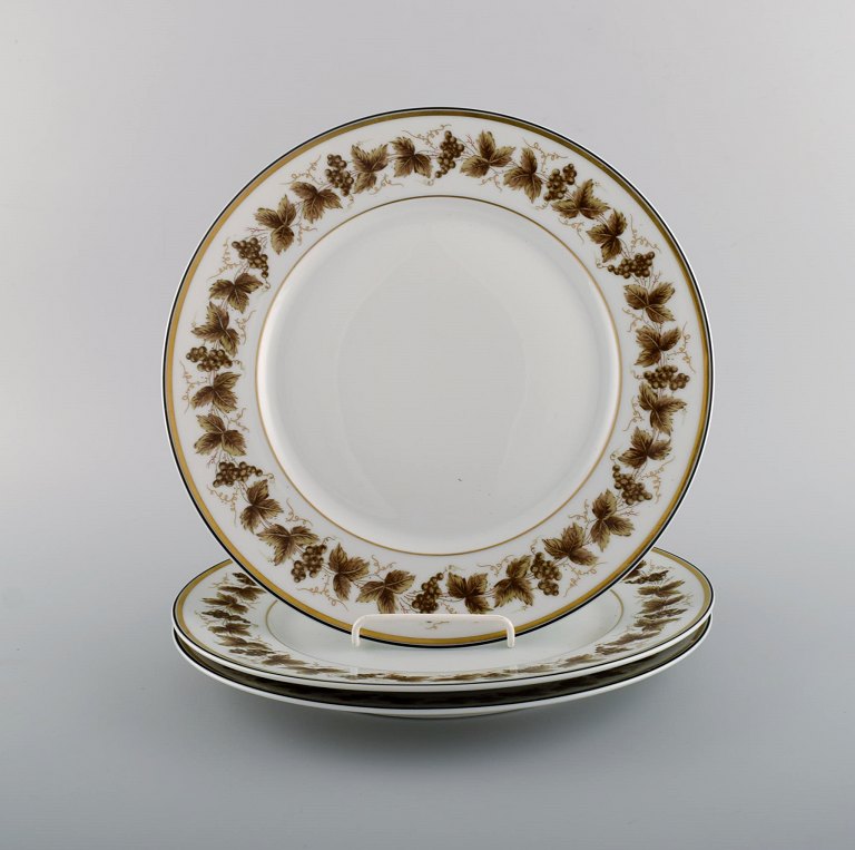 Tre store Limoges tallerkener i porcelæn med håndmalede vindrueranker og 
gulddekoration. 1930/40