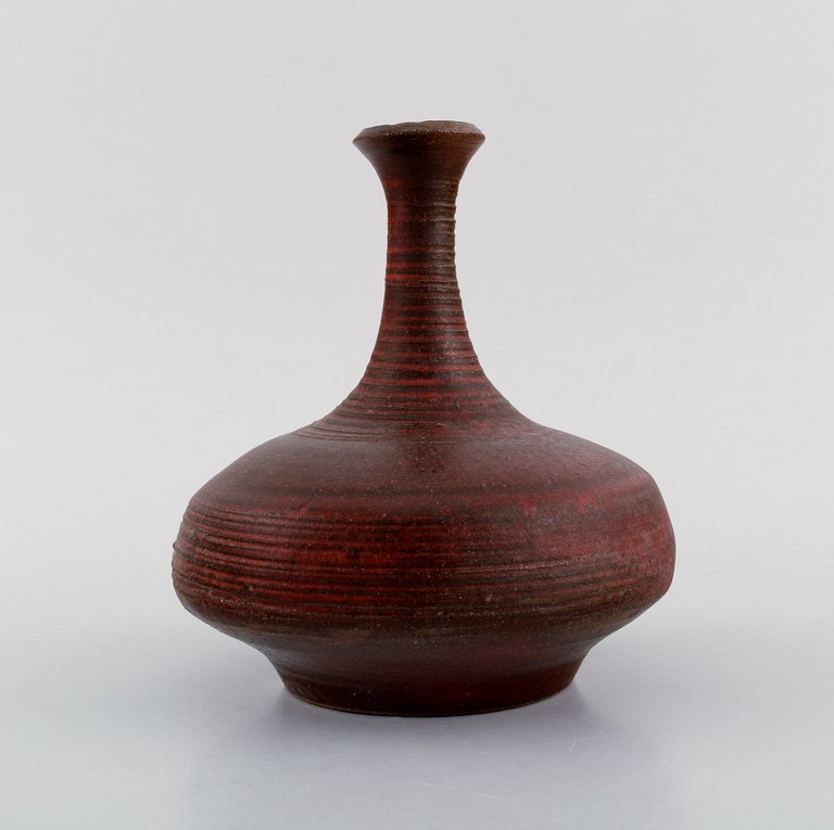 European studio ceramicist. Narrow neck unique vase in glazed stoneware. 
Beautiful glaze in reddish brown shades. Late 20th century.

