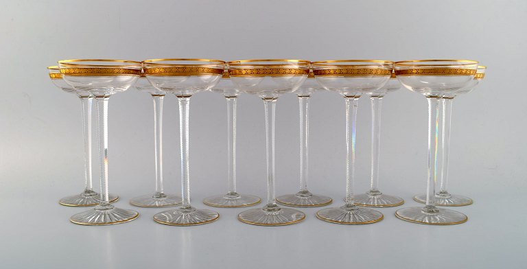 Baccarat, Frankrig. 11 art deco champagneskåle i mundblæst krystalglas med 
gulddekoration i form af blade. 1930