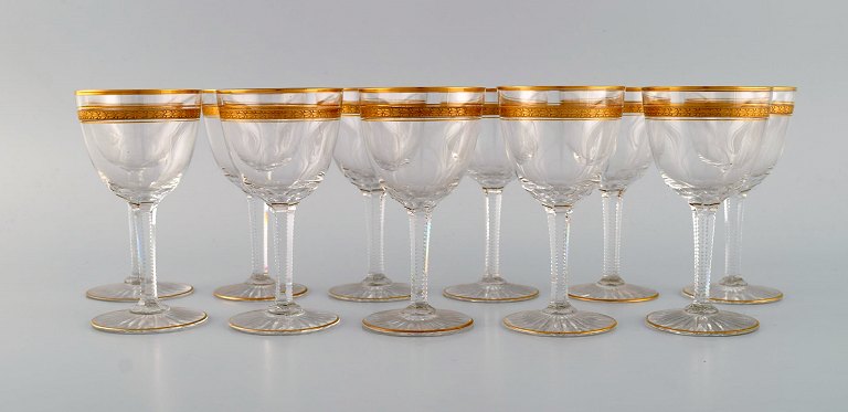 Baccarat, Frankrig. 11 art deco hvidvinsglas i mundblæst krystalglas med 
gulddekoration i form af blade. 1930