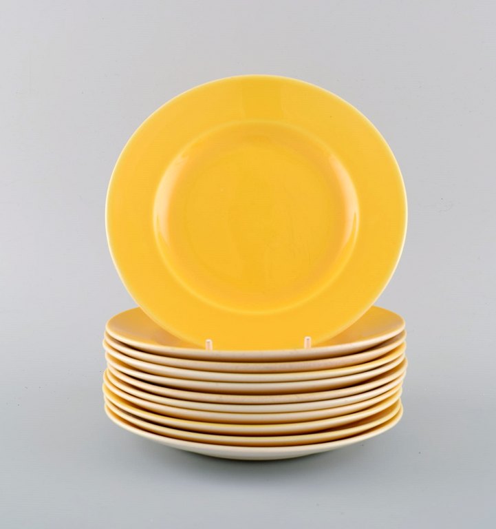 11 Royal Copenhagen / Aluminia Confetti plates in yellow glazed faience. 
Mid-20th century.
