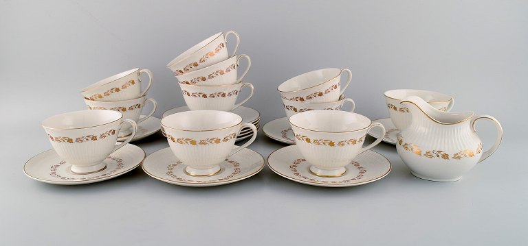 Royal Doulton, England. Tolv Fairfax tekopper med underkopper og flødekande i 
porcelæn med håndmalede blomster i guld. Midt 1900-tallet.
