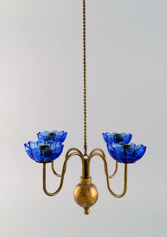 Gunnar Ander for Ystad Metall. Chandelier for four candles in brass and 
mouth-blown art glass shaped like flowers. Scandinavian design, mid 20th 
century.
