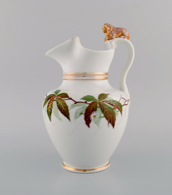 Antique Bing & Grøndahl chocolate jug in porcelain modeled with a lion on the 
handle. Hand-painted flowers and gold decoration. 1870s.
