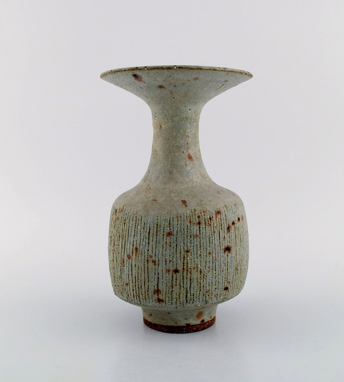 Lucie Rie (f. 1902, d. 1995, østrigsk-født britisk keramiker. Stor modernistisk 
unika vase i glaseret keramik / stentøj. Smuk glasur i grå nuancer. Rillet 
korpus. Trumpet formet munding. Eget værksted, ca. 1970.
