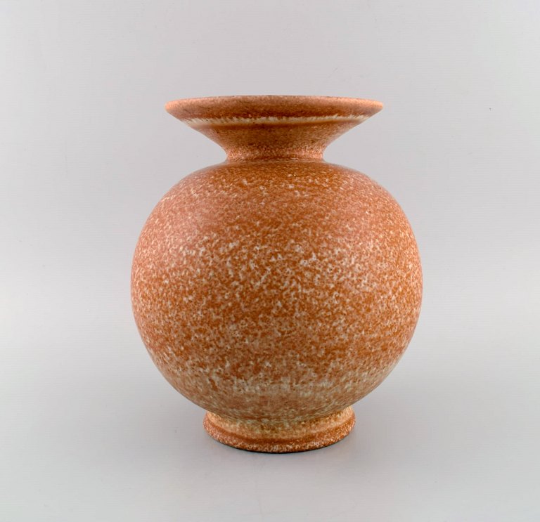 Bo fajans, Sweden. Round Topas vase in glazed ceramics. Beautiful speckled glaze 
in orange and sand shades. 1960s.
