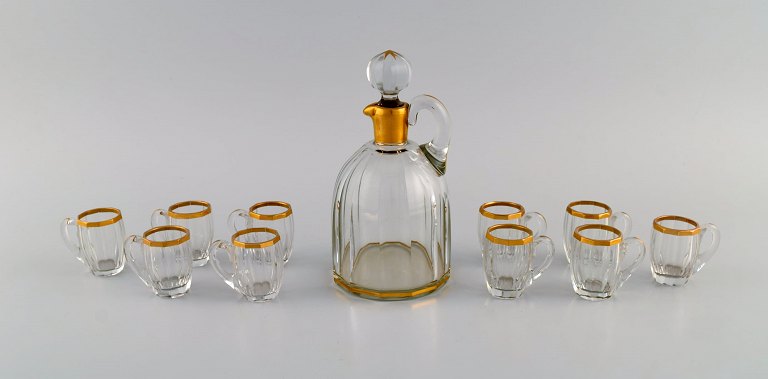 Baccarat, France. Art deco vodka service for 10 people. Mouth blown crystal 
glass with gold edge. 1930s.
