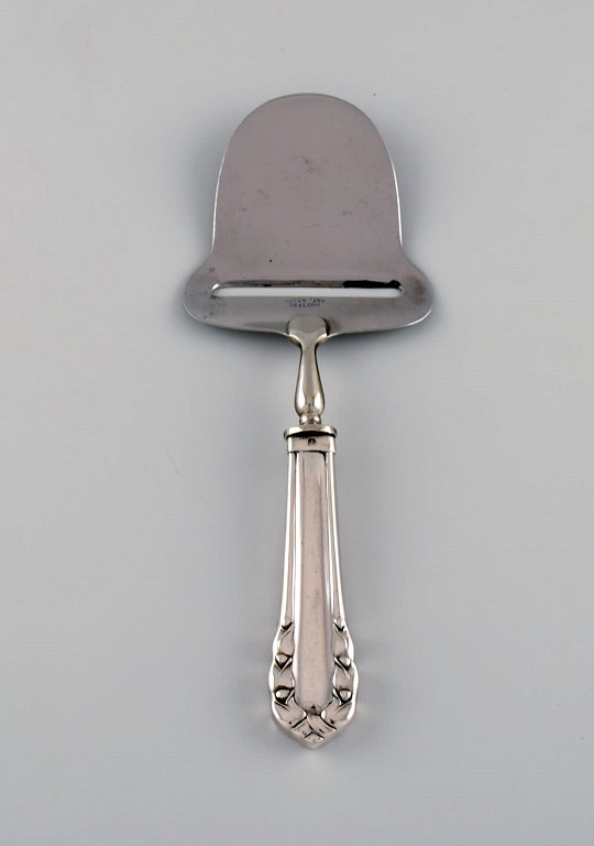 Tidlig Georg Jensen Liljekonval ostehøvl i sølv (830) og rustfrit stål. Dateret 
1915-1930.
