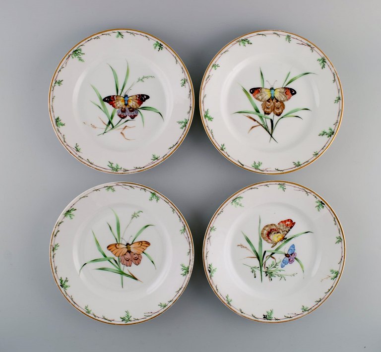 Fire antikke Royal Copenhagen middagstallerkener i porcelæn med håndmalede 
blomster, sommerfugle og guldkant. Midt 1800-tallet.
