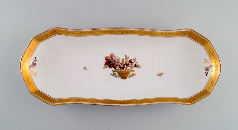 Aflangt Royal Copenhagen Guldkurv serveringsfad i porcelæn med blomster og 
gulddekoration. Modelnummer 595/9442. Tidligt 1900-tallet.
