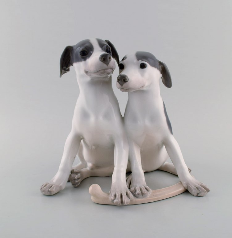 Large and rare Royal Copenhagen porcelain figure. Puppies with bone. Model 
number 750. Early 20th century.
