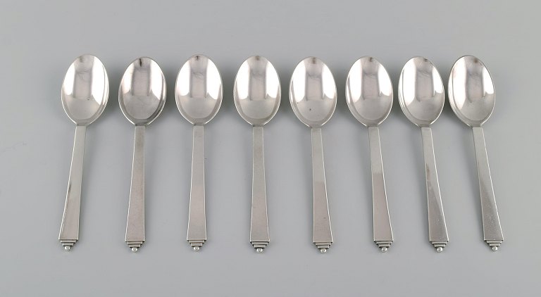 Eight Georg Jensen Pyramid dessert spoons in sterling silver.
