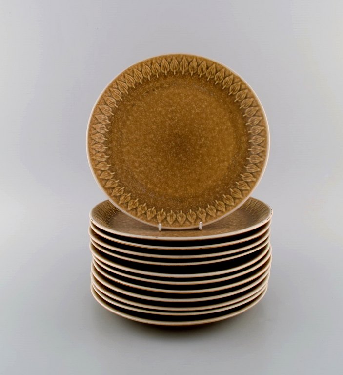 Jens H. Quistgaard (1919-2008) for Bing & Grøndahl. Twelve Relief dinner plates 
in glazed stoneware. Beautiful glaze in mustard yellow shades. 1960s.
