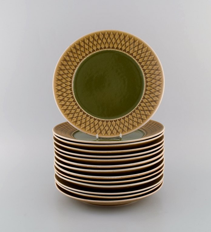 Jens H. Quistgaard (1919-2008) for Bing & Grøndahl. 14 Relief dinner plates in 
glazed stoneware. Beautiful glaze in mustard yellow and green shades. 1960s.
