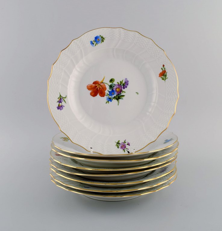 Royal Copenhagen Saksisk Blomst. Otte middagstallerkener i håndmalet porcelæn 
med blomster og gulddekoration. Modelnummer 493/1621. Dateret 1953.
