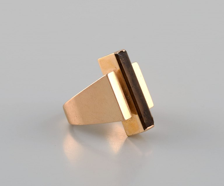 Large modernist Georg Jensen ring in 18 carat gold adorned with smoky quartz. 
Dated 1945-1951.
