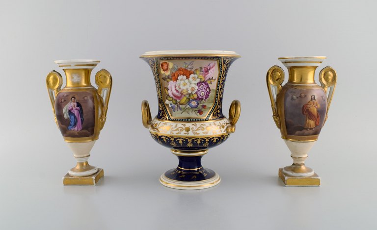 Tre antikke empire vaser i håndmalet porcelæn. Religiøse motiver, blomster og 
gulddekoration. 1800-tallet.
