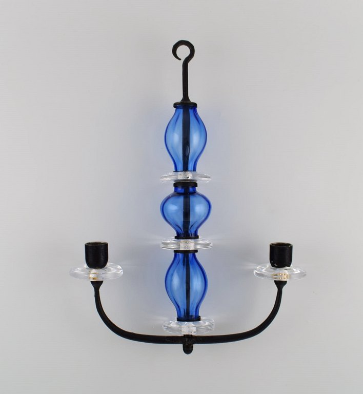 Erik Höglund (1932-1998) for Kosta Boda. Rare two-armed candlestick for hanging 
in cast iron and mouth-blown art glass. Mid-20th century.

