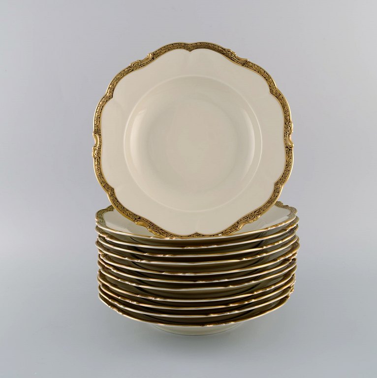 KPM, Berlin. Twelve Royal Ivory deep plates in cream-colored porcelain with gold 
decoration. 1920s.
