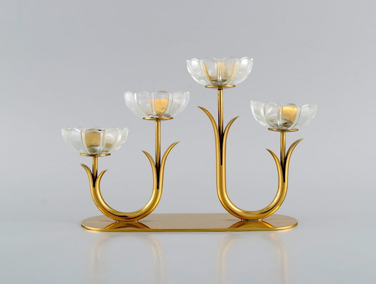 Gunnar Ander for Ystad Metall. Candlestick in brass and clear art glass shaped 
like flowers. 1950s.
