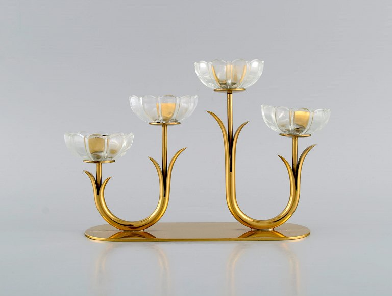 Gunnar Ander for Ystad Metall. Lysestage i messing og klart kunstglas formet som 
blomster. 1950