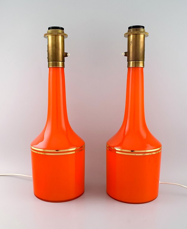 Anders Pehrson for Ateljé Lyktan. To store bordlamper i orange mundblæst 
kunstglas med gulddekoration. 1960