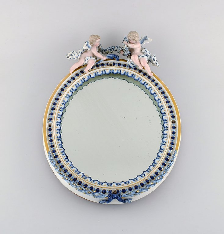 Antikt Meissen porcelænsspejl med originalt glas. Dekoreret med engle og 
pousserende blomster. Sent 1800-tallet.
