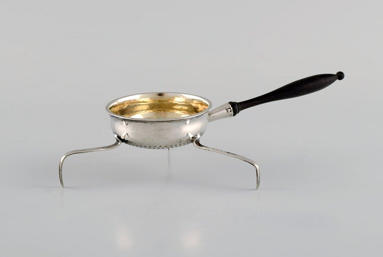 European silversmith. Antique silver tea strainer on tripod with shaft in turned 
ebony. Gilded inside. 1800s.
