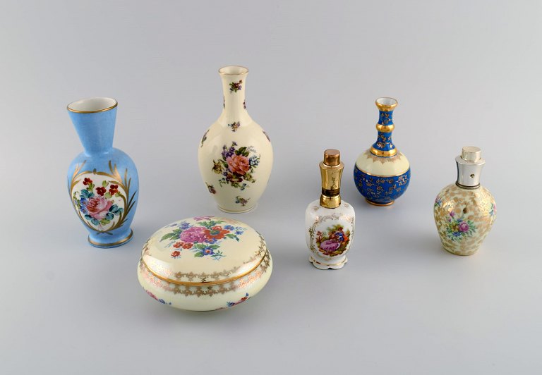 Limoges, France. Two perfume bottles, three vases and lidded box in hand-painted 
porcelain. Flowers and gold decoration. 1930s / 40s.
