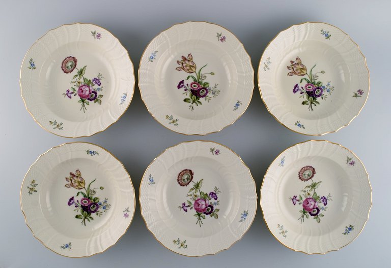 Seks Royal Copenhagen Frijsenborg dybe tallerkener i håndmalet porcelæn med 
blomster og guldkant. 1950