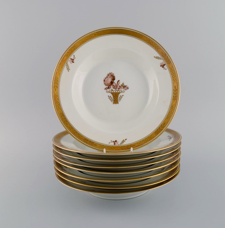 Otte Royal Copenhagen Guldkurv dybe tallerkener i håndmalet porcelæn med 
blomster og gulddekoration. 1960