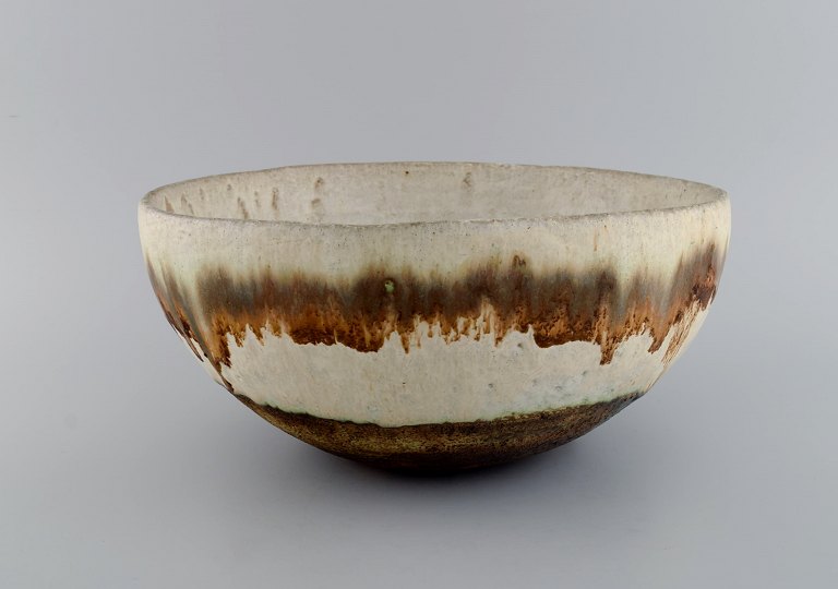 European studio ceramicist. Large unique bowl in glazed ceramics. Beautiful 
running glaze in light earth shades. 1960s / 70s.
