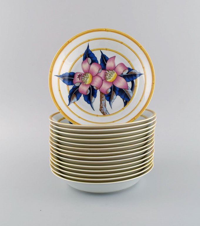 Porcelaine de Paris. "Aurore Tropicale". 15 dybe tallerkener i porcelæn 
dekoreret med blomster og bambus. 1980