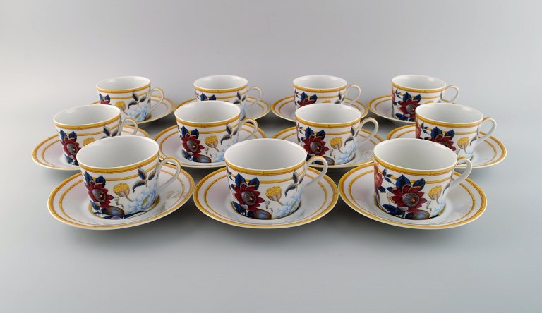 Porcelaine de Paris. "Aurore Tropicale". 11 coffee cups with saucers decorated 
with flowers and pomegranates. 1980s.
