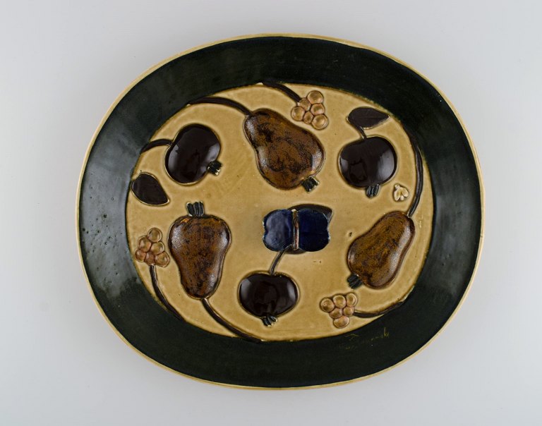 Timo Sarvimäki (b. 1948) for Designhuset. Oval dish in glazed ceramics with 
fruits and butterfly in relief. Finnish design, 1970s.
