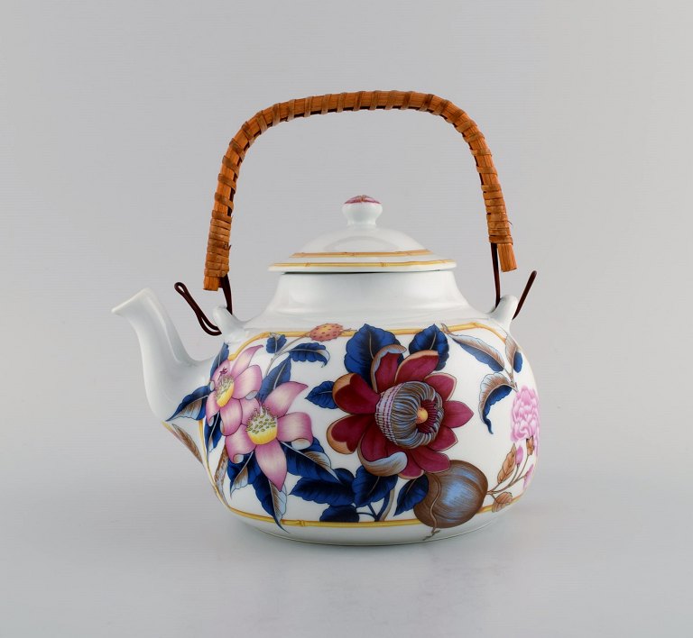 Porcelain of Paris. "Tropical Aurore". Porcelain teapot with wicker handle 
decorated with flowers, pomegranates and bamboo. 1980s.
