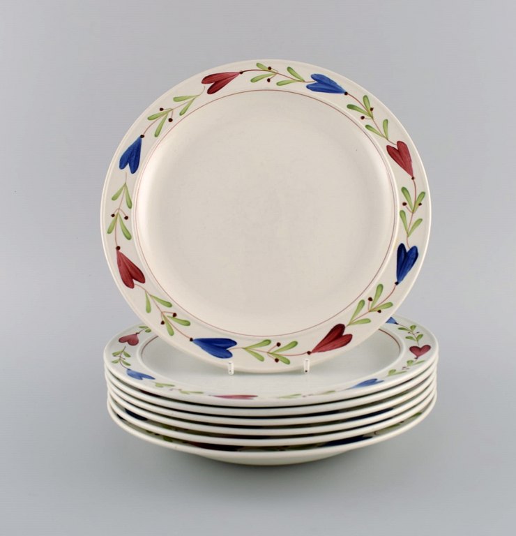 Stig Lindberg (1916-1982) for Gustavsberg. Seven Ranka porcelain dinner plates 
with hand-painted flowers and foliage. Mid 20th century.
