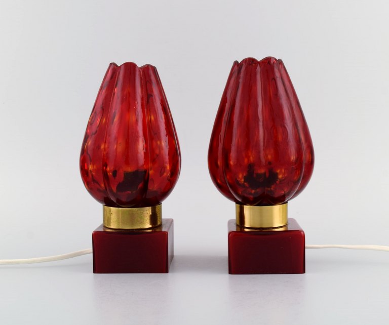 Hans Agne Jakobsson for A/B Markaryd. Et par bordlamper i messing og rødt 
mundblæst kunstglas formet som blomsterblade. Svensk design, 1960/70