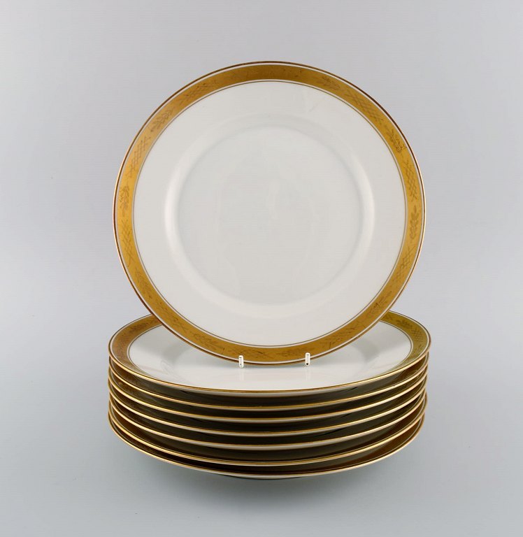 Royal Copenhagen service no. 607. Eight porcelain dinner plates. Gold border 
with foliage. Model number 607/9586. Dated 1944.
