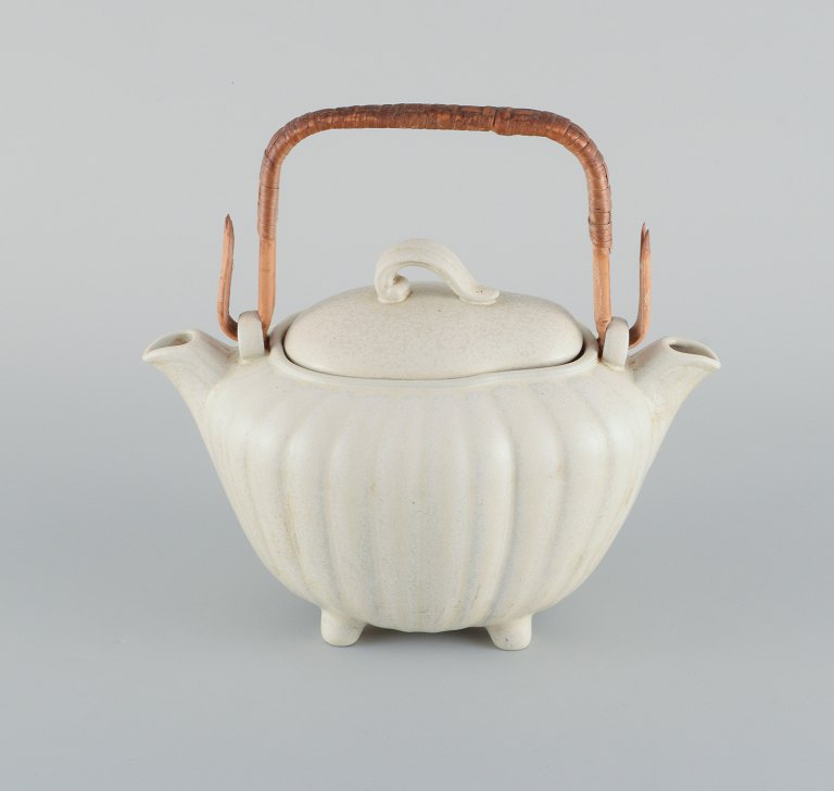Gunnar Nylund for Rörstrand. Double jug in glazed ceramic. 
Cream colored eggshell glaze and wicker handle.