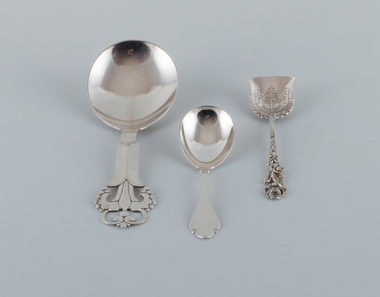 A collection of three silver spoons.