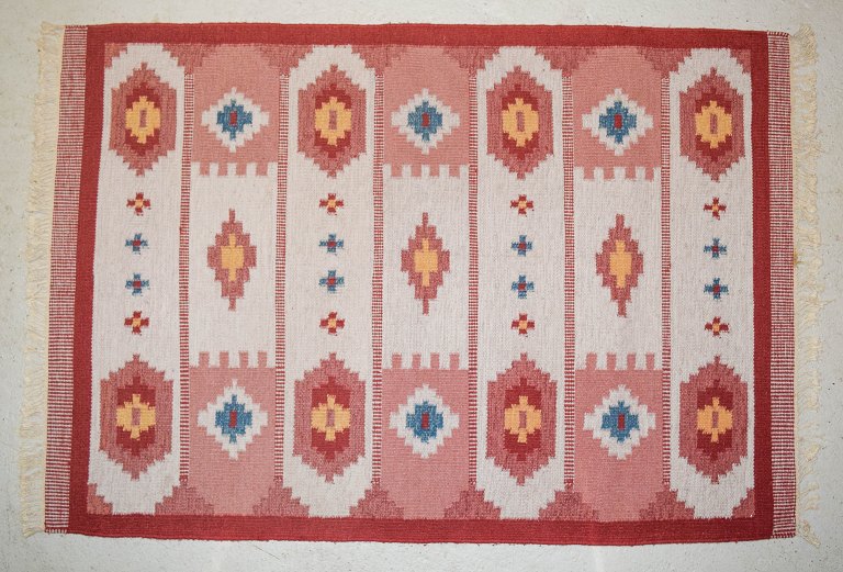 Svensk tekstildesigner. Håndvævet RÖLAKAN tæppe med frynser i ren uld med 
geometriske felter og rene linjer.