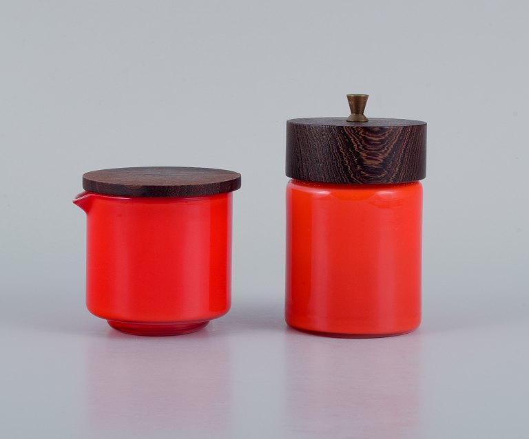 Michael Bang for Holmegaard.
Pepper mill and creamer in orange and white art glass with wooden lid.
